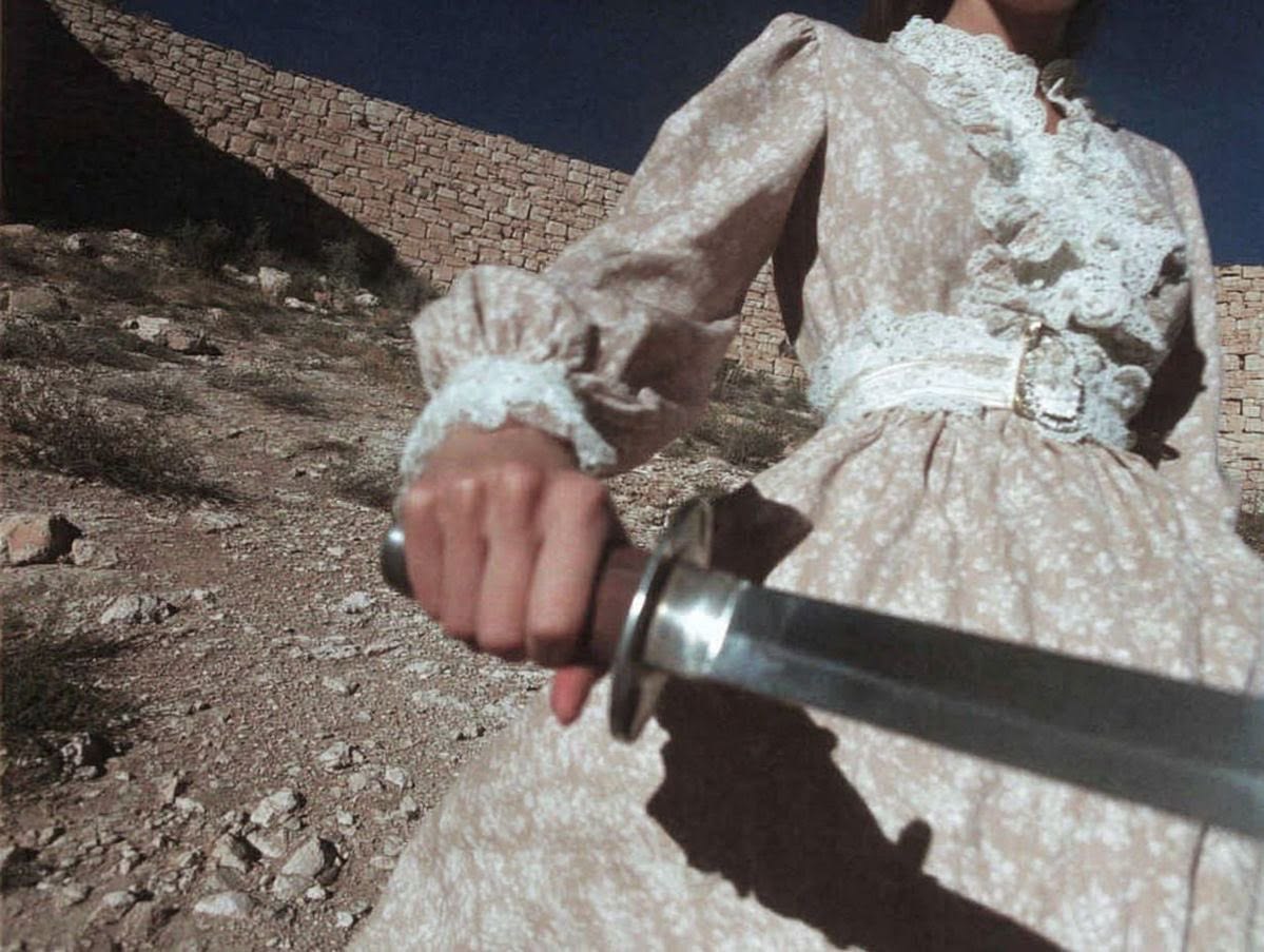 Mujer con vestido floral sosteniendo una espada